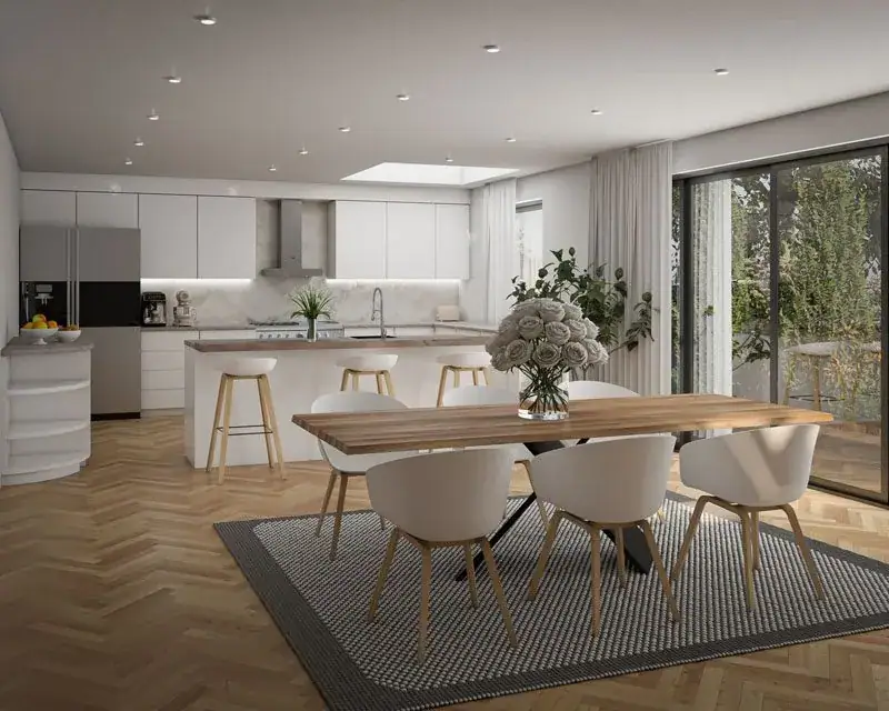 Open-plan kitchen and dining room with herringbone oak floor, white island and sliding doors to the garden